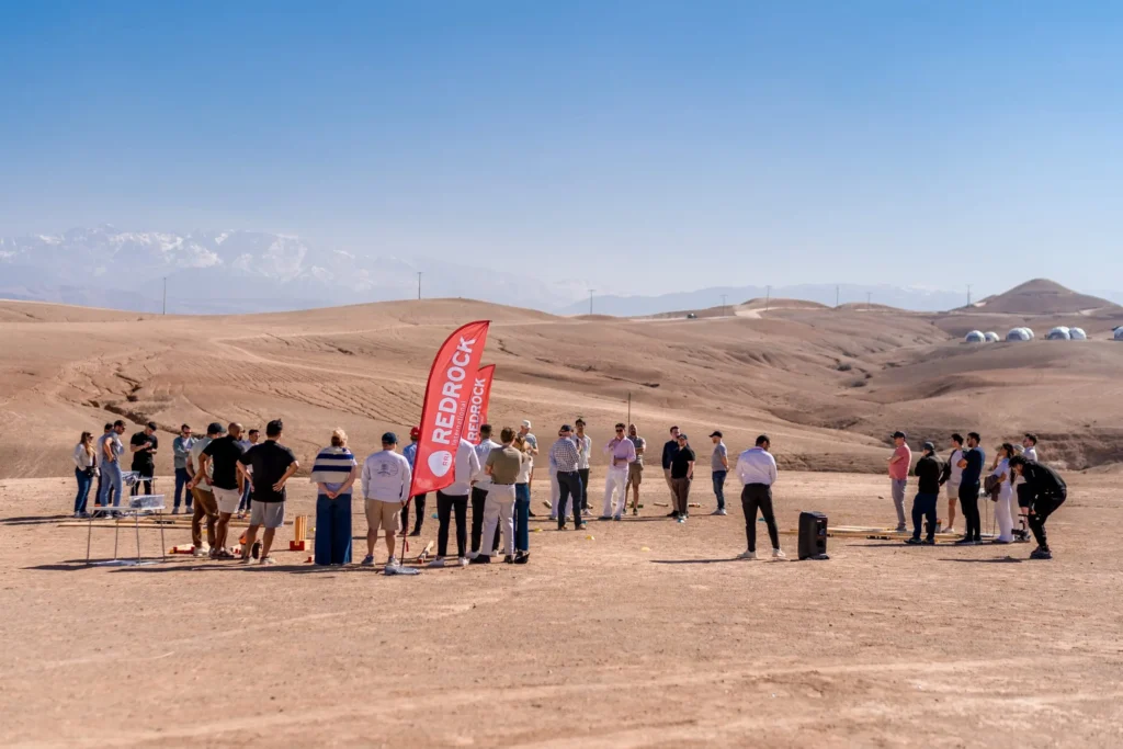 Dasseti group of 30 standing in the desert about to start a team building activity called bridges